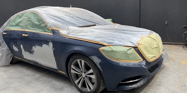 Sedan masked and sanded during bodywork preparation at M&A