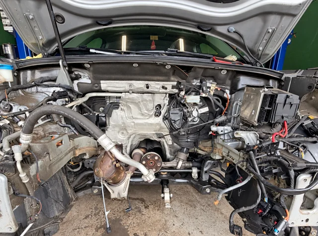 Vehicle engine bay with the engine removed during repair at M&A