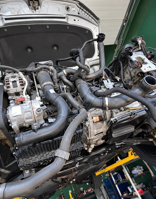 Removed engine assembly with hoses and wiring at M&A