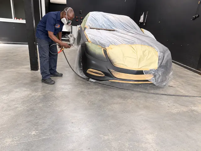 Vehicle body panels being prepared for paint in the workshop
